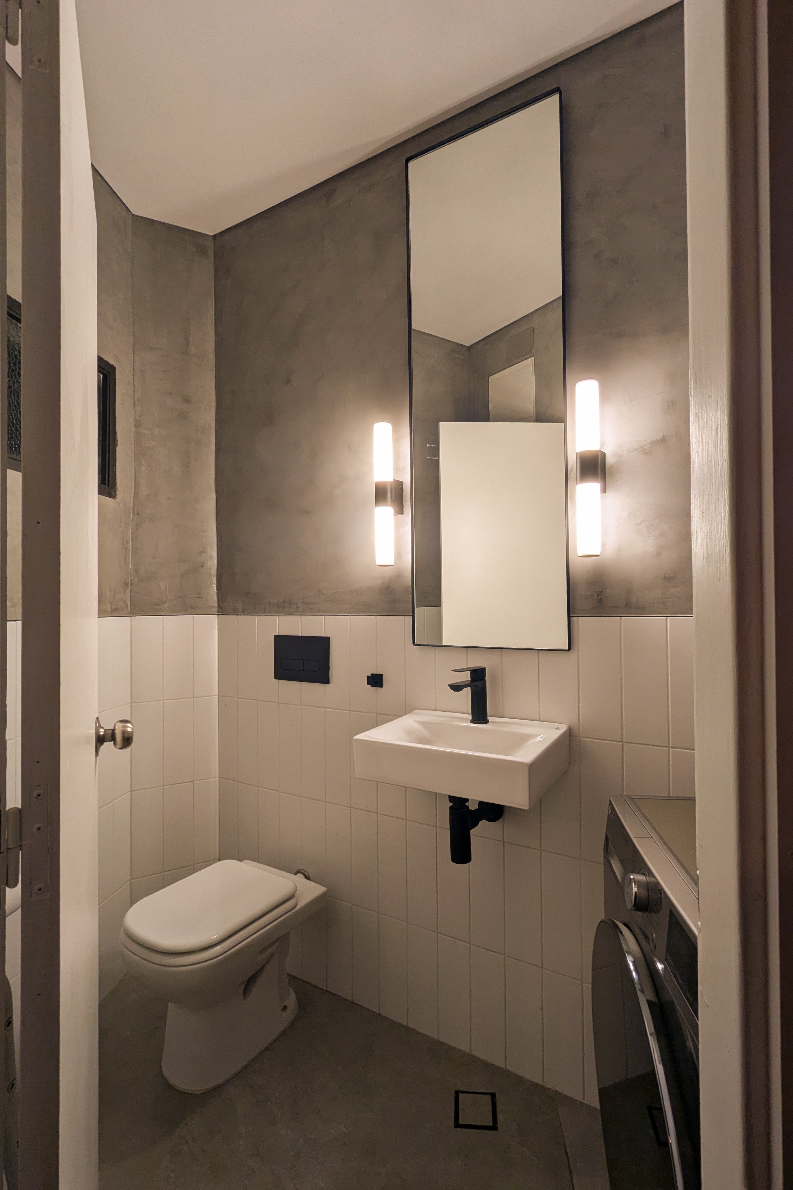 Fotografía del baño con espejo, iluminación y mueble suspendido
