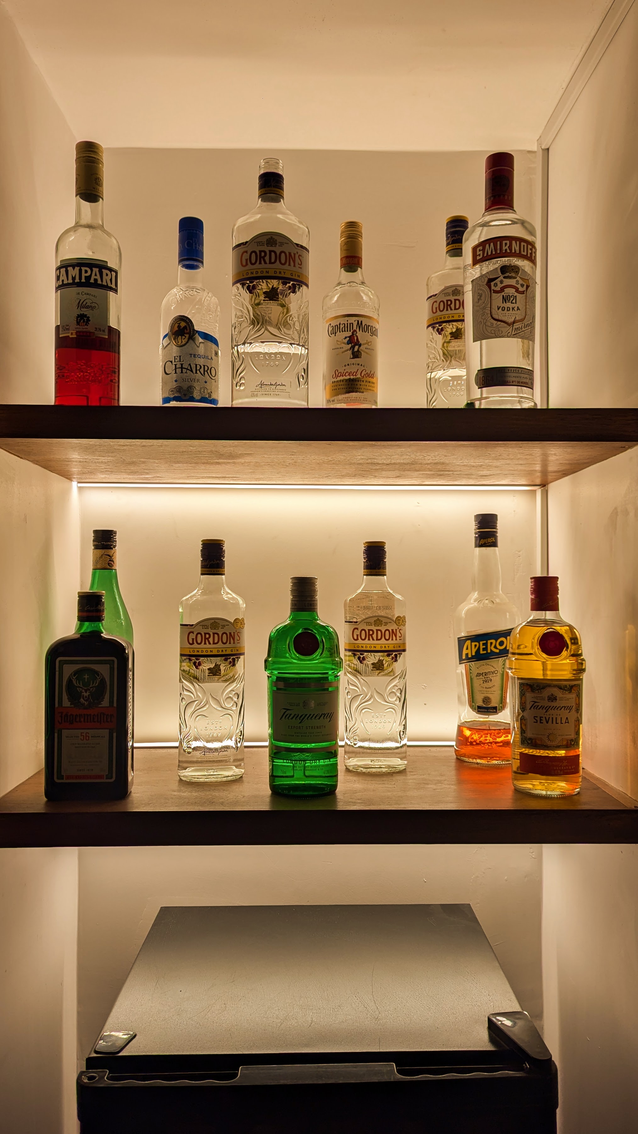 Fotografía de la estantería iluminada con botellas