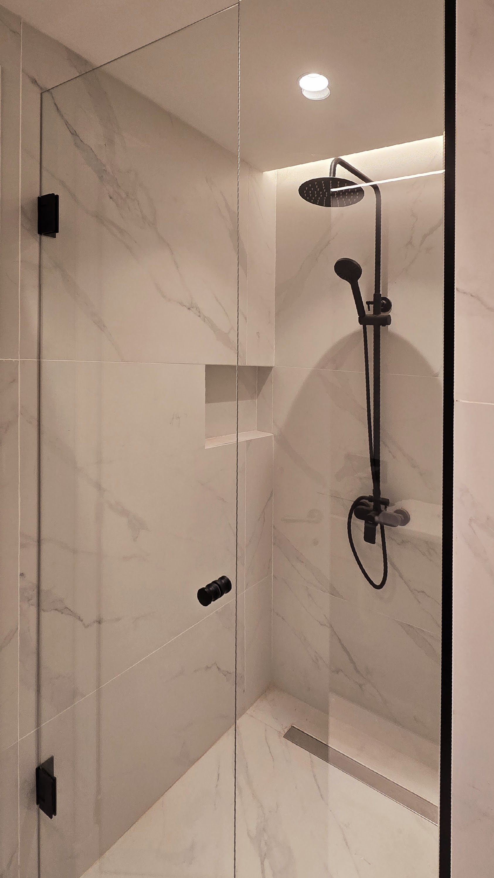 Inodoro junto a mueble en tono nogal con ducha higiénica en negro mate